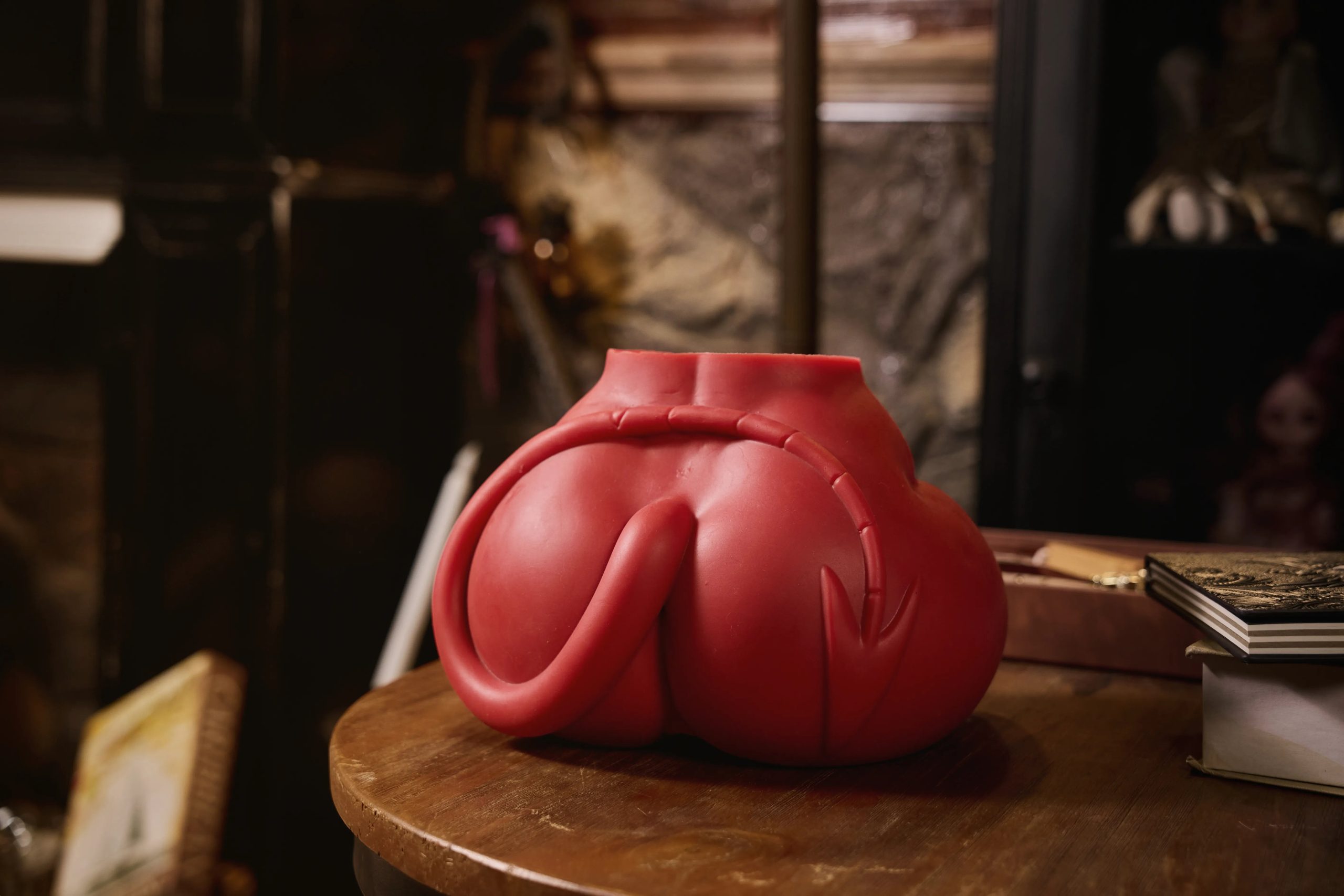 Back side view highlighting the realistically sculpted red demon tail curved over the hip of the Meru silicone torso