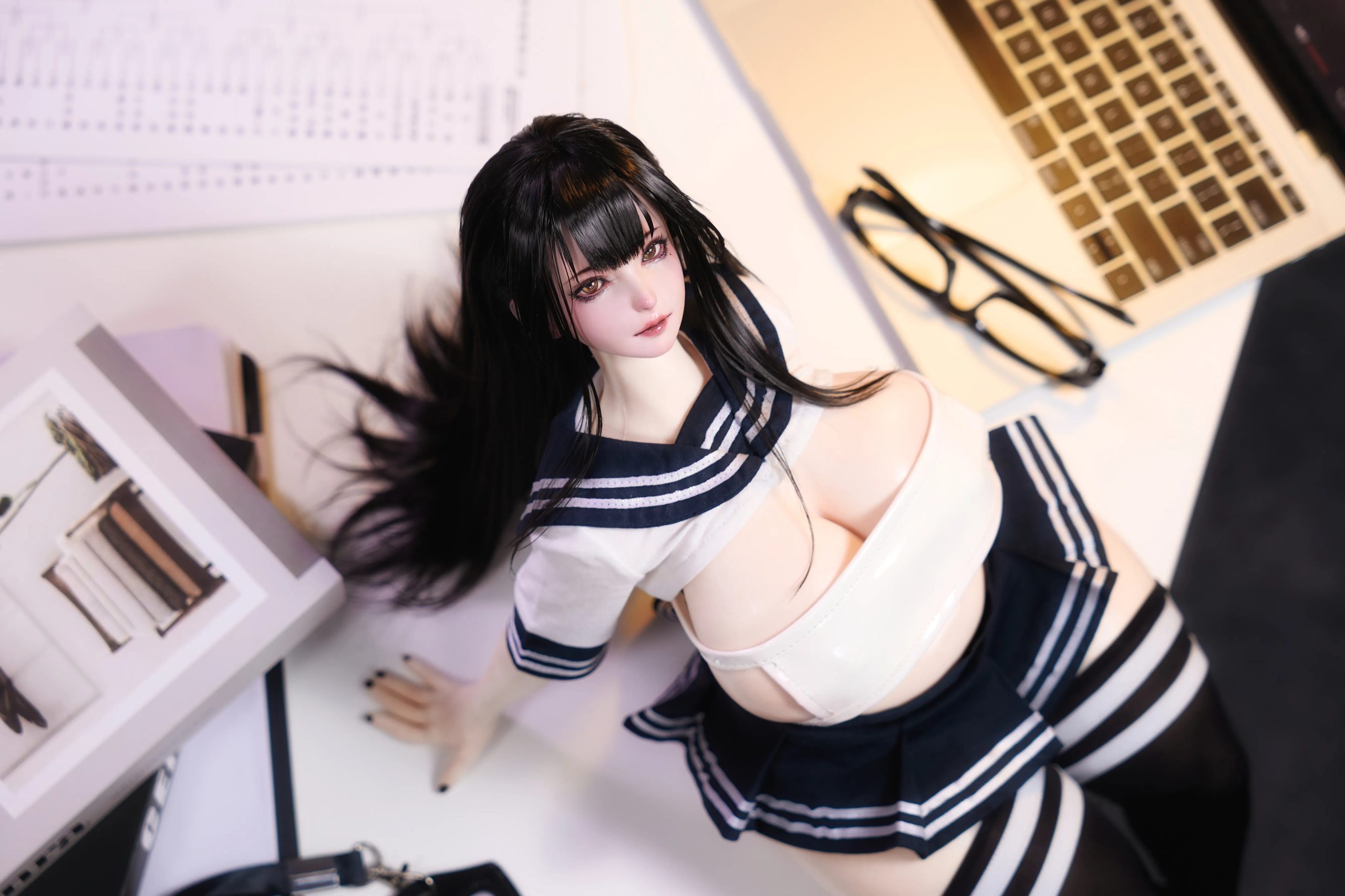 Miyu mini anime sex doll with a chubby silicone body posed on a white desk
