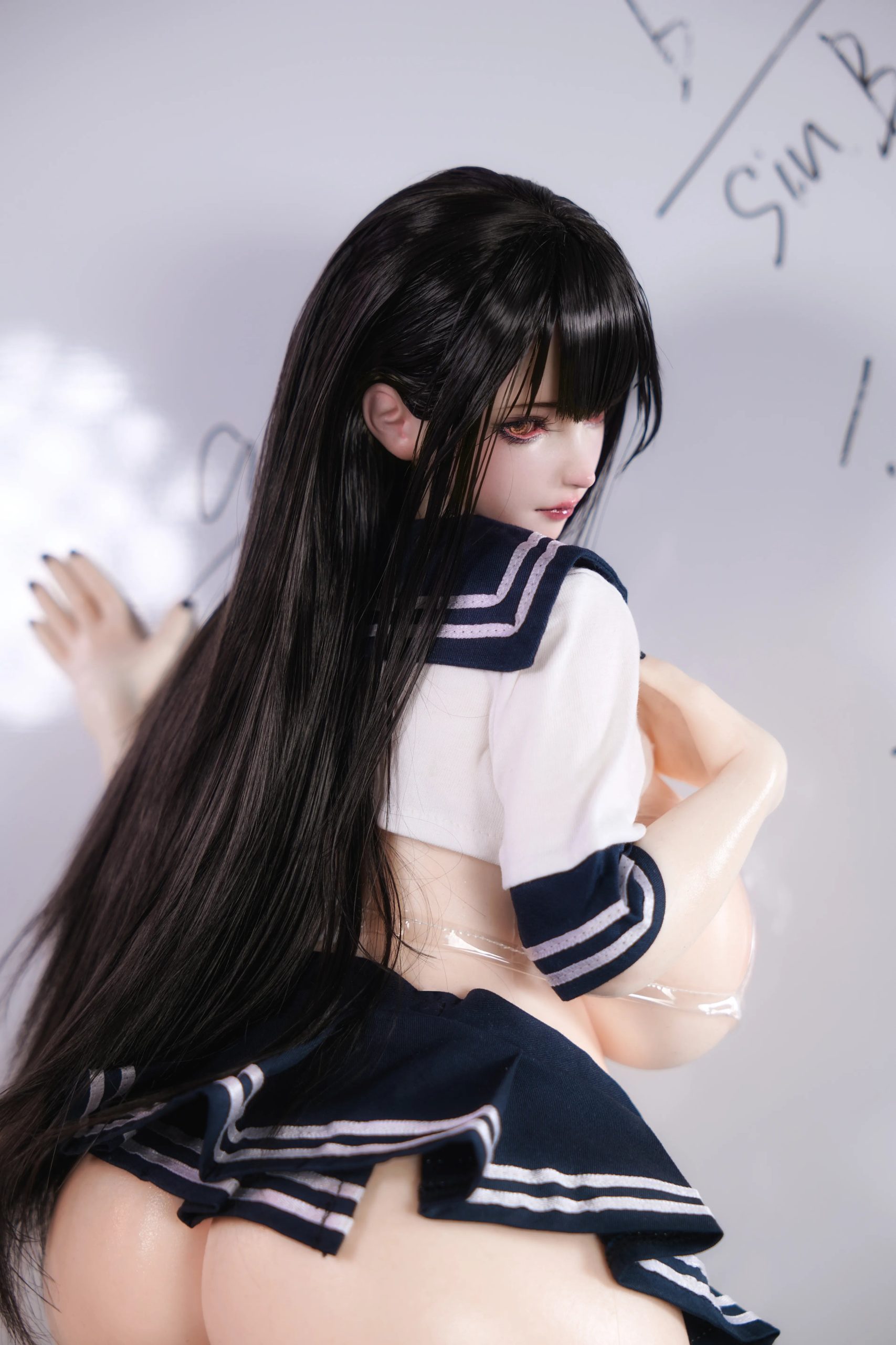 Rear three-quarter view of Miyu showing long black hair and her curvy silicone body