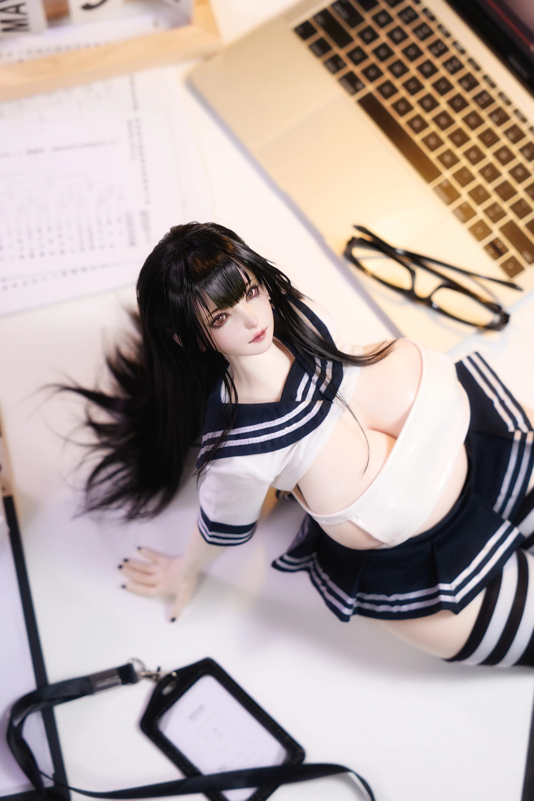Top-down view of Miyu mini anime sex doll posed beside a laptop and desk accessories